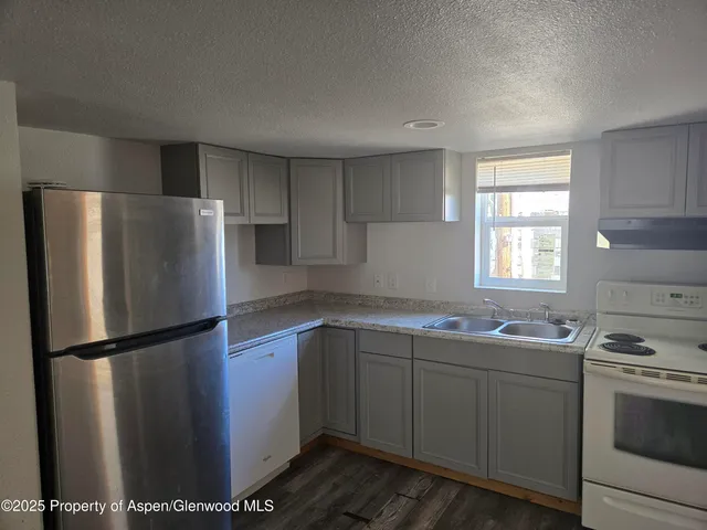 a kitchen with stainless steel appliances granite countertop a refrigerator sink and stove