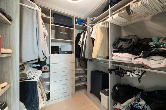a view of walk in closet with clothes and shoes