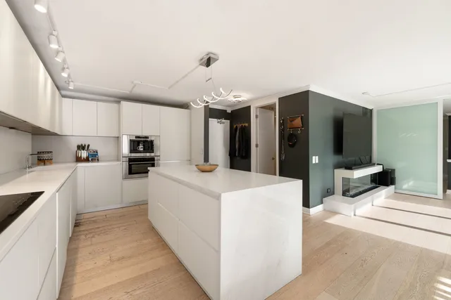 a large white kitchen with cabinets a sink and a stove