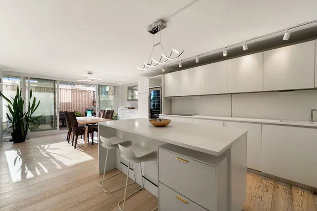a kitchen with a sink cabinets and wooden floor