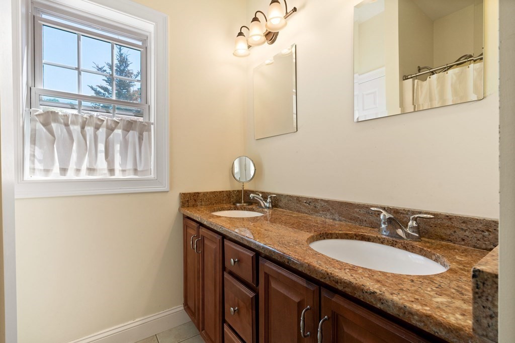 2 Hannah Dodge Road, Unit A Littleton, MA 01460 - Photo 15 of 28 a bathroom with a granite countertop sink and a mirror