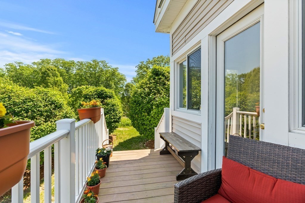 2 Hannah Dodge Road, Unit A Littleton, MA 01460 - Photo 26 of 28 a balcony with wooden floor table and chairs