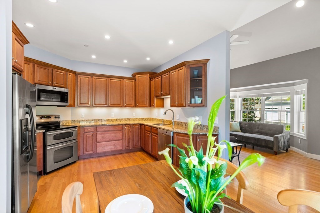 2 Hannah Dodge Road, Unit A Littleton, MA 01460 - Photo 5 of 28 a kitchen with stainless steel appliances granite countertop sink stove top oven and cabinets