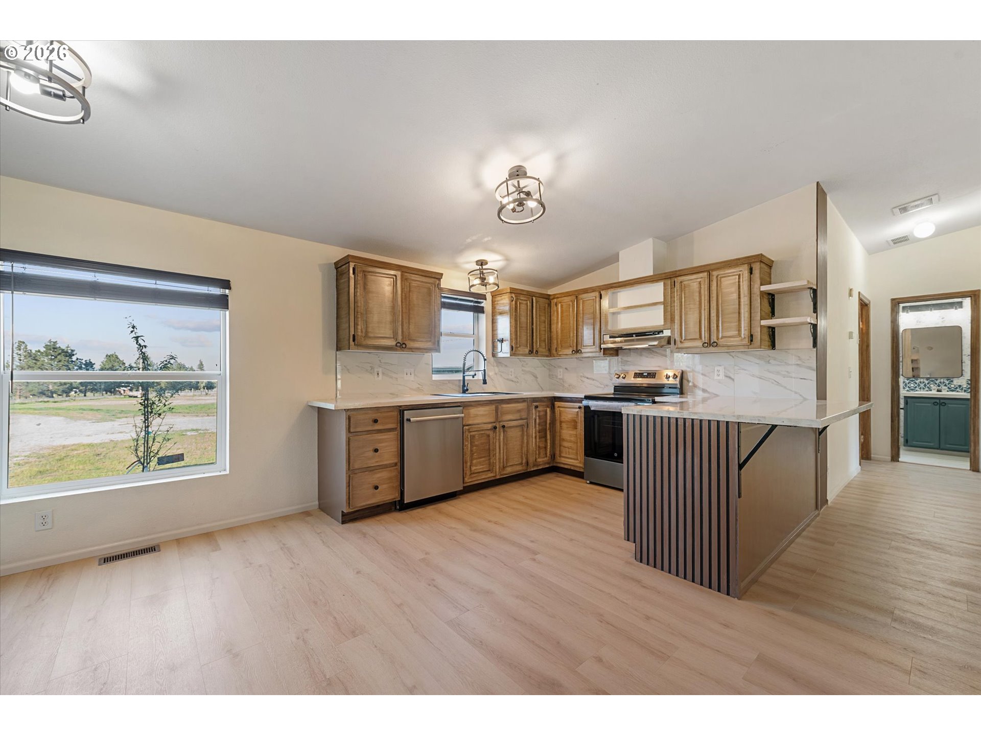 14386 Ben-Dier Road Baker City, OR 97814 - Photo 10 of 42 a large kitchen with kitchen island a large counter top space a sink stainless steel appliances and cabinets