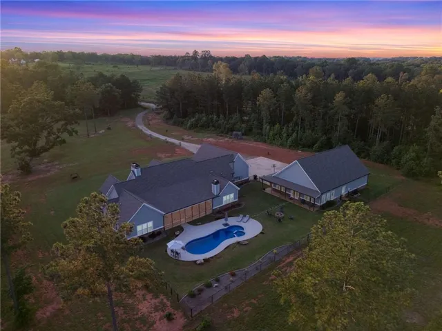 an aerial view of residential houses with outdoor space and trees