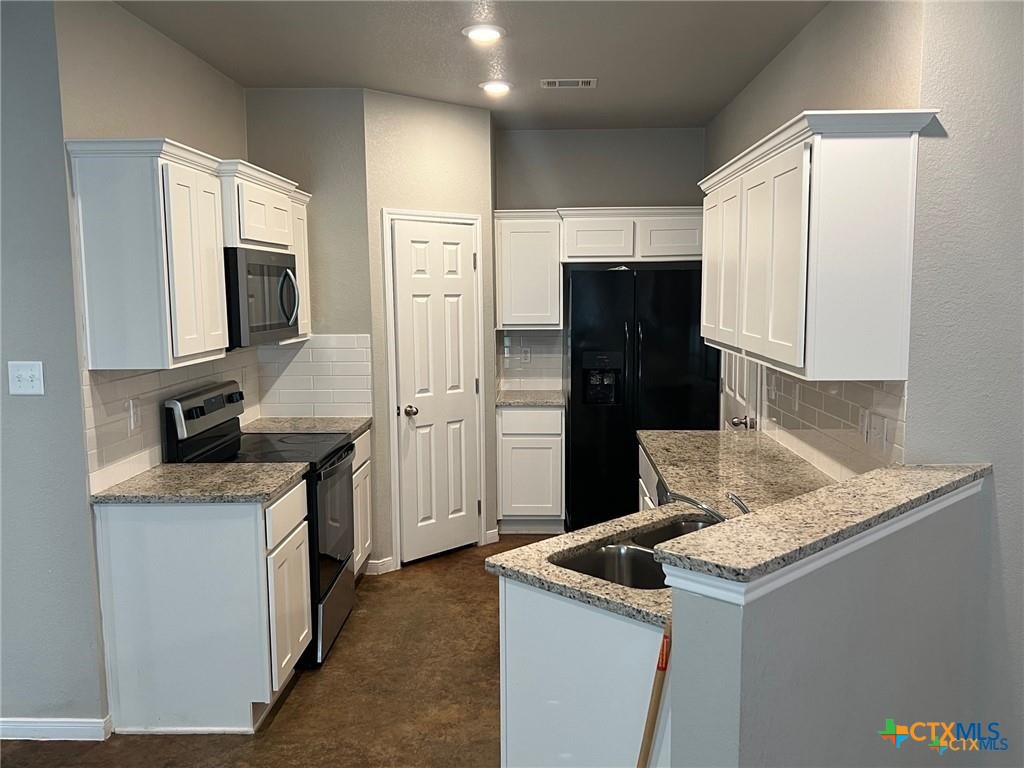 117 East Valley Road Harker Heights, TX 76548 - Photo 2 of 33 a kitchen with granite countertop kitchen island stainless steel appliances a refrigerator stove top oven and sink