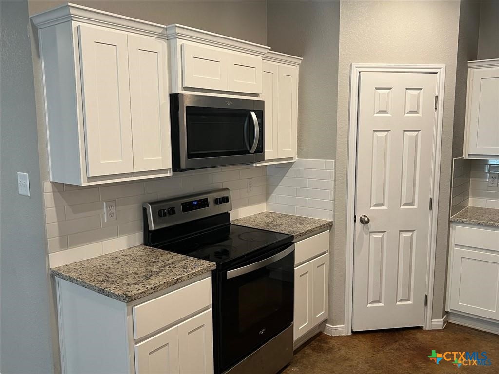 117 East Valley Road Harker Heights, TX 76548 - Photo 3 of 33 a kitchen with granite countertop white cabinets stainless steel appliances and sink