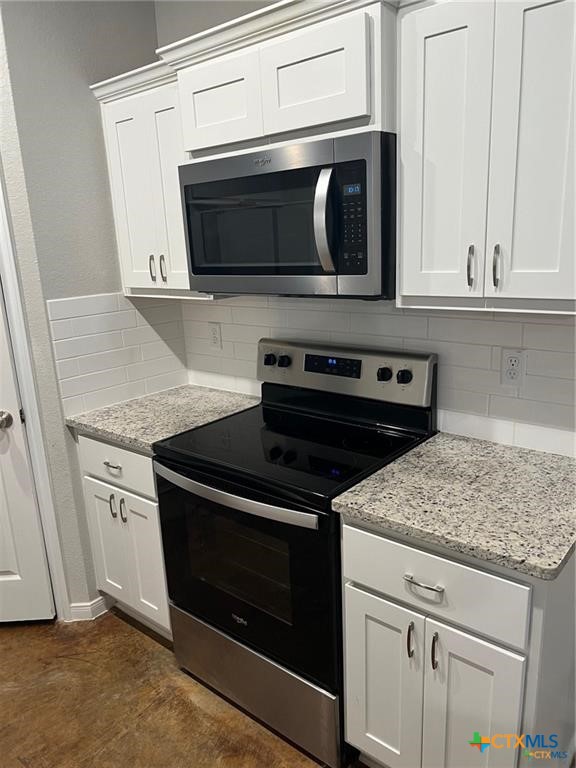 117 East Valley Road Harker Heights, TX 76548 - Photo 6 of 33 a kitchen with stainless steel appliances granite countertop white cabinets and a stove a oven with wooden floor