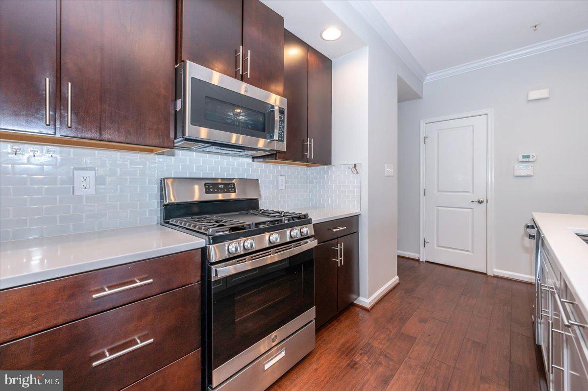 5059 Small Gains Way, Unit 5059 Frederick, MD 21703 - Photo 22 of 57 a kitchen with a stove and a microwave