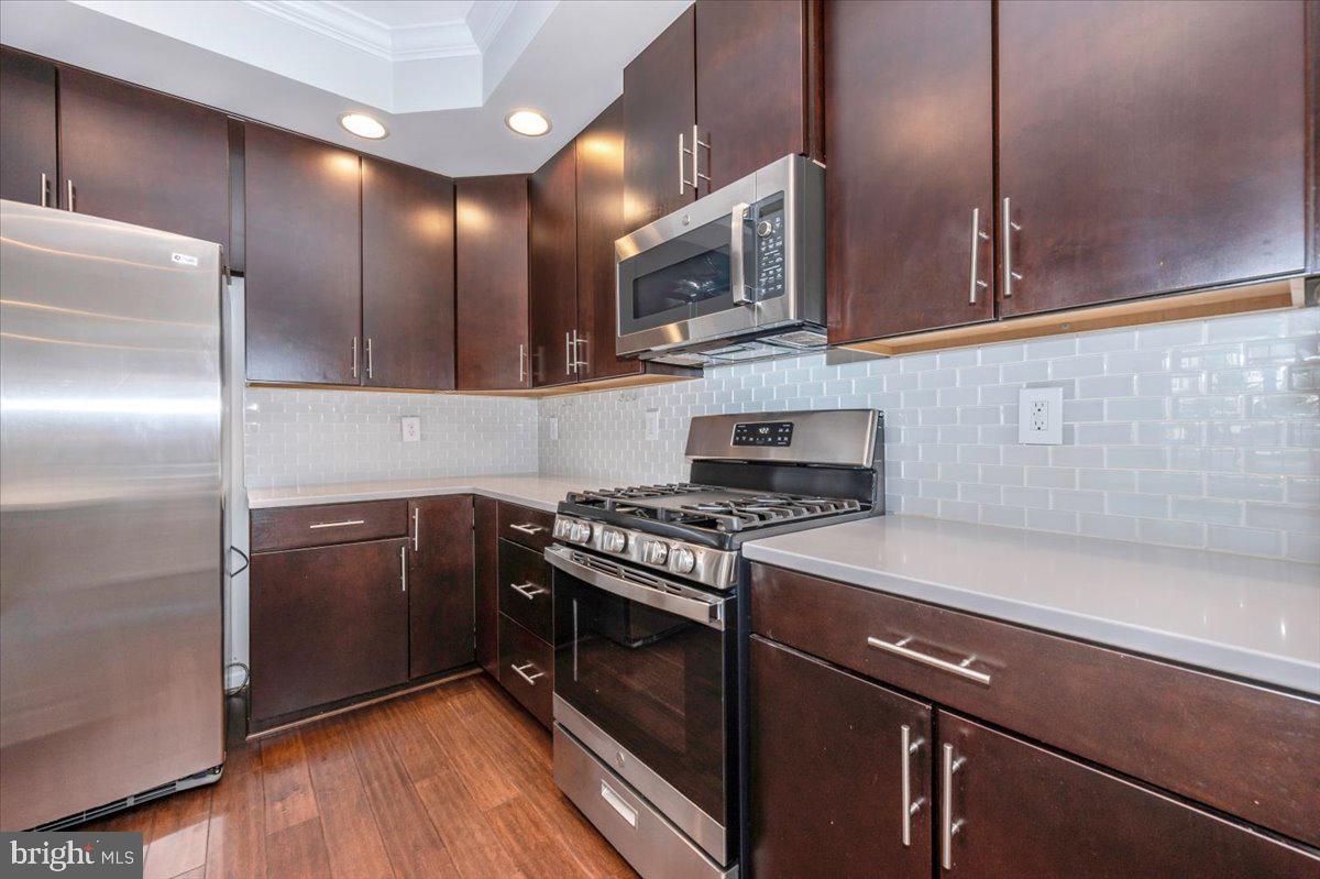 5059 Small Gains Way, Unit 5059 Frederick, MD 21703 - Photo 23 of 57 a kitchen with stainless steel appliances granite countertop a stove a sink and a refrigerator