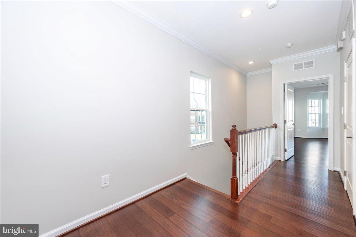 5059 Small Gains Way, Unit 5059 Frederick, MD 21703 - Photo 26 of 57 a view of a hallway with wooden floor and stairs