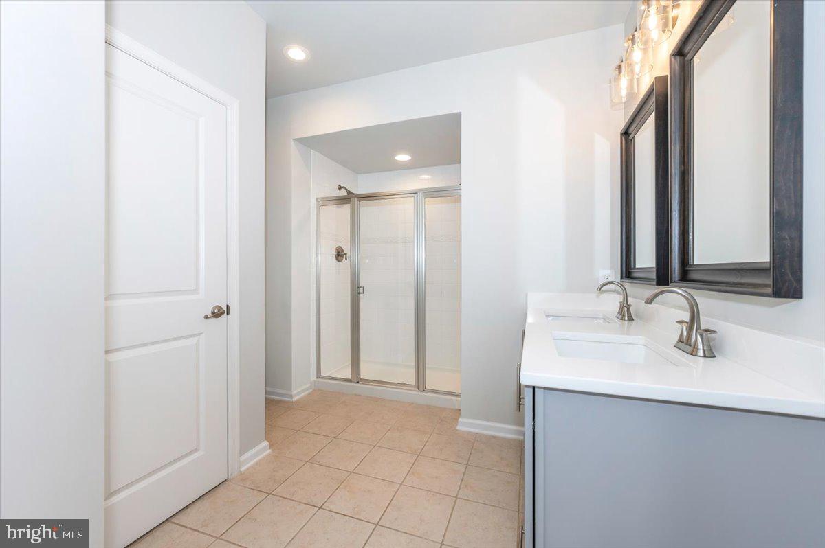 5059 Small Gains Way, Unit 5059 Frederick, MD 21703 - Photo 31 of 57 a bathroom with a double vanity sink and a mirror