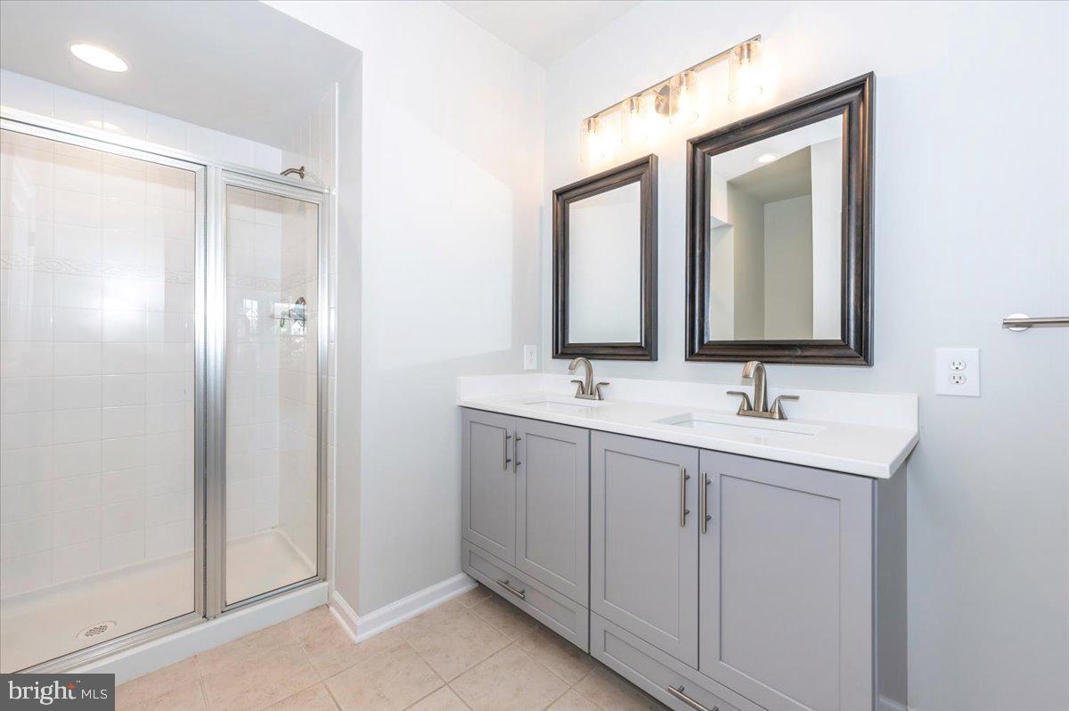 5059 Small Gains Way, Unit 5059 Frederick, MD 21703 - Photo 33 of 57 a bathroom with 2 sink and a mirror