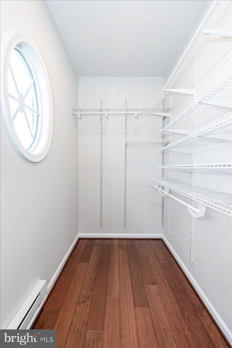 5059 Small Gains Way, Unit 5059 Frederick, MD 21703 - Photo 35 of 57 a view of a room with wooden floor and white walls