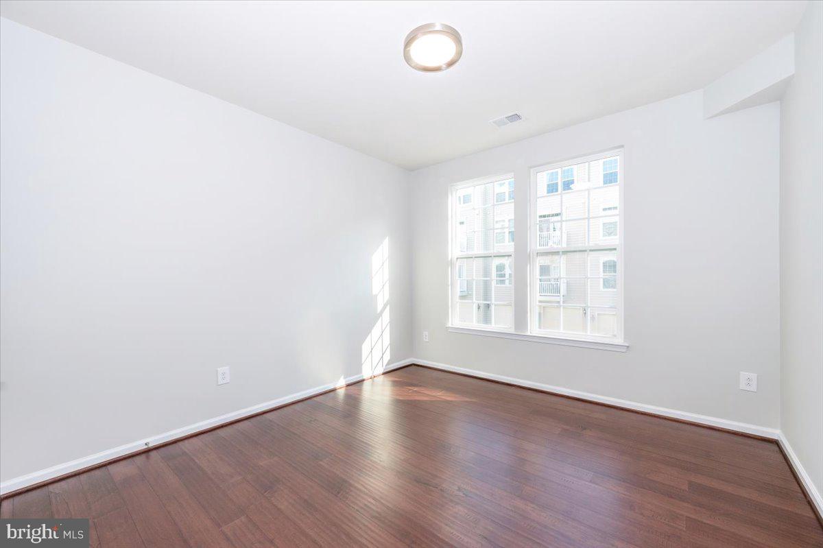 5059 Small Gains Way, Unit 5059 Frederick, MD 21703 - Photo 38 of 57 an empty room with wooden floor and windows