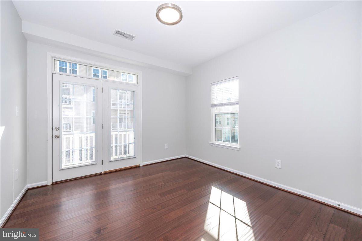 5059 Small Gains Way, Unit 5059 Frederick, MD 21703 - Photo 40 of 57 an empty room with wooden floor and windows