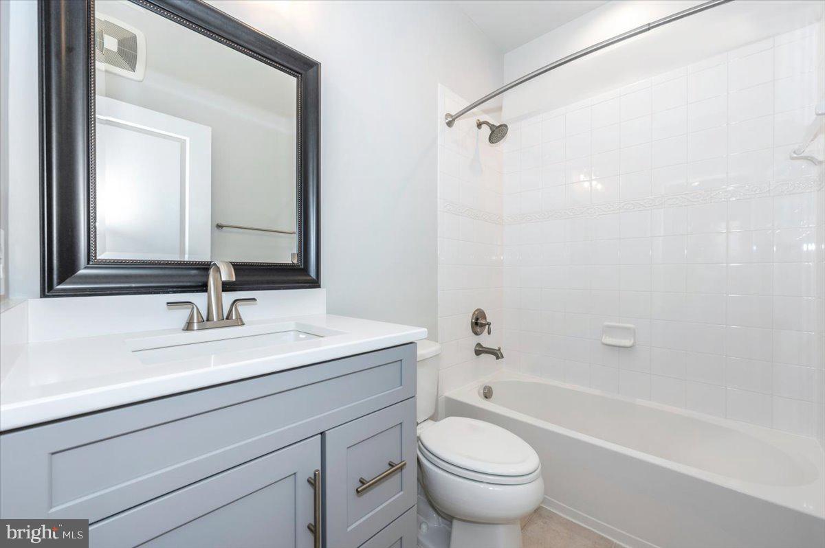 5059 Small Gains Way, Unit 5059 Frederick, MD 21703 - Photo 41 of 57 a bathroom with a granite countertop sink a toilet and a mirror