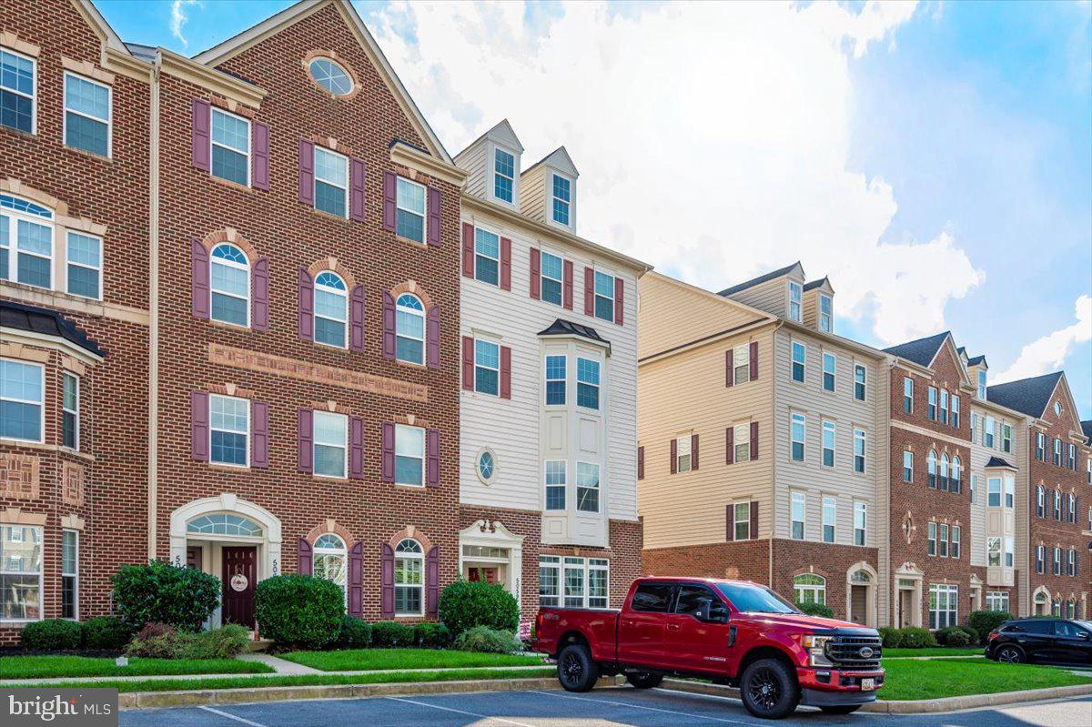 5059 Small Gains Way, Unit 5059 Frederick, MD 21703 - Photo 55 of 57 a front view of a building with lot of cars parked