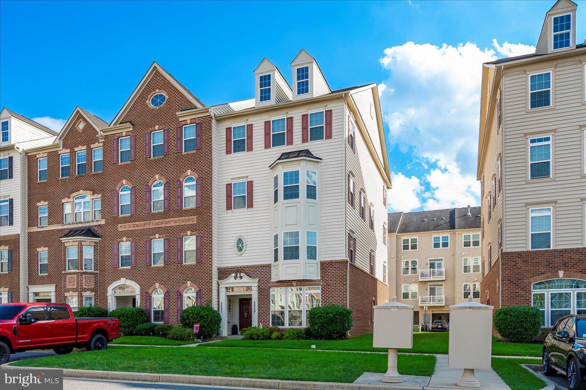 5059 Small Gains Way, Unit 5059 Frederick, MD 21703 - Photo 57 of 57 a front view of a residential apartment building with a yard
