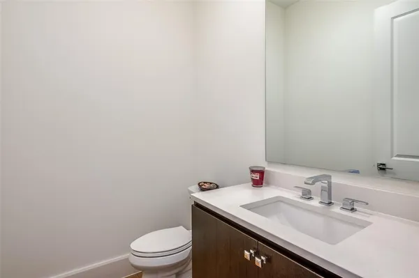 a bathroom with a granite countertop sink a toilet and a mirror