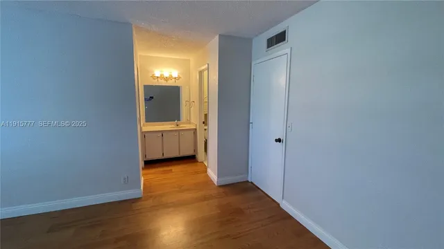 a view of a room with wooden floor and a bathroom