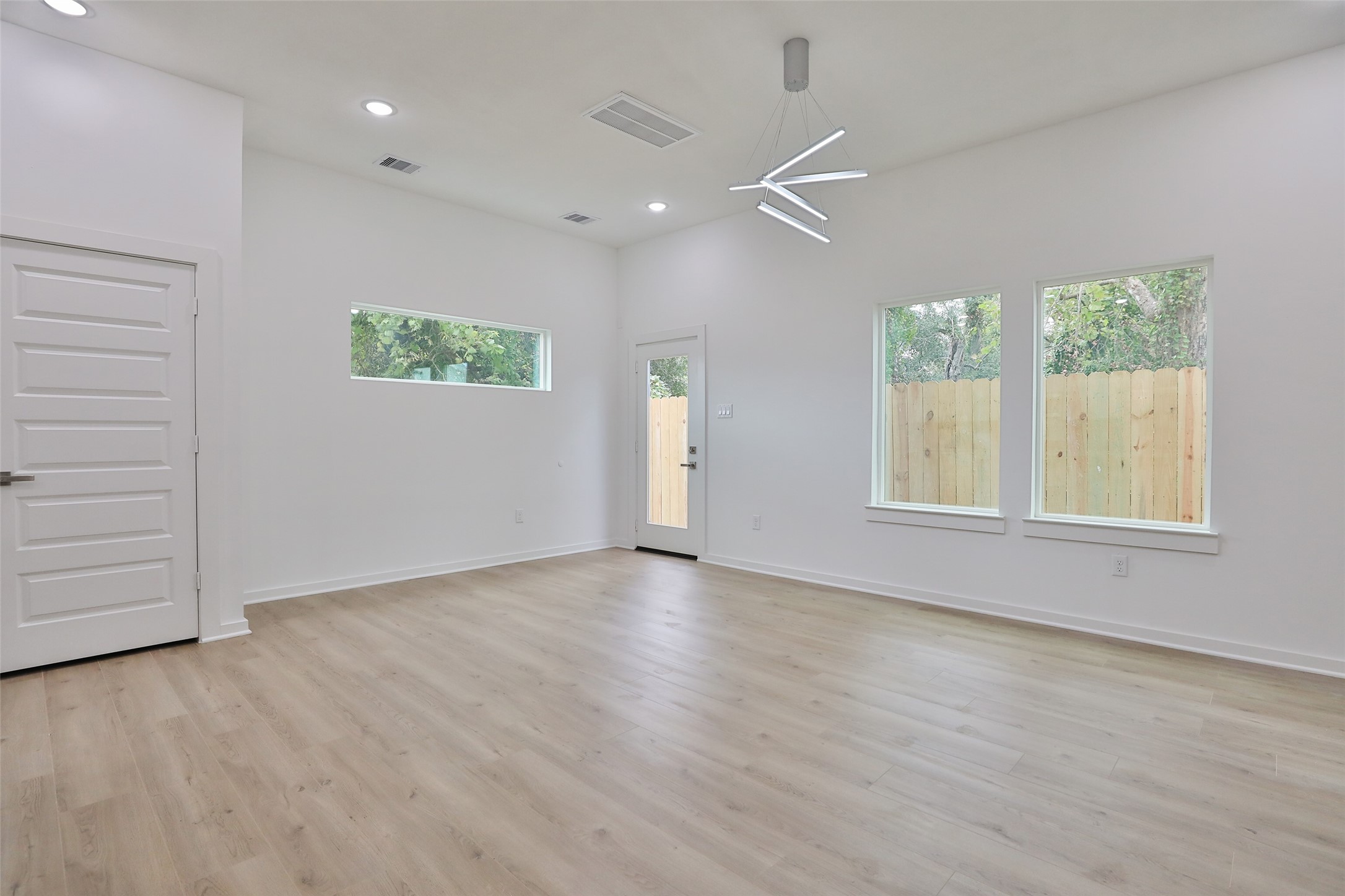 9349 Lavender Street Houston, TX 77016 - Photo 8 of 29 an empty room with wooden floor and windows