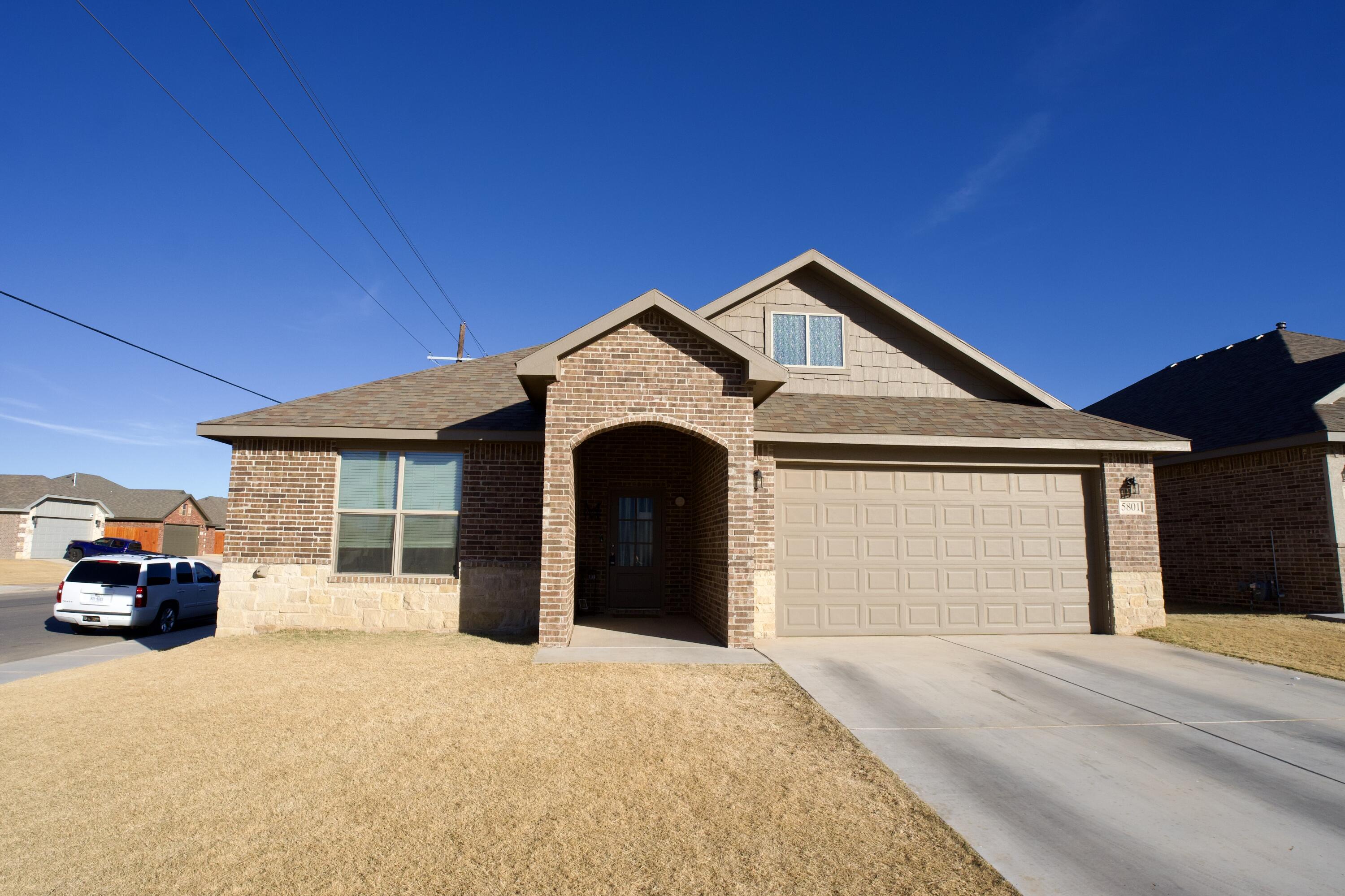 a front view of a house with cars parked