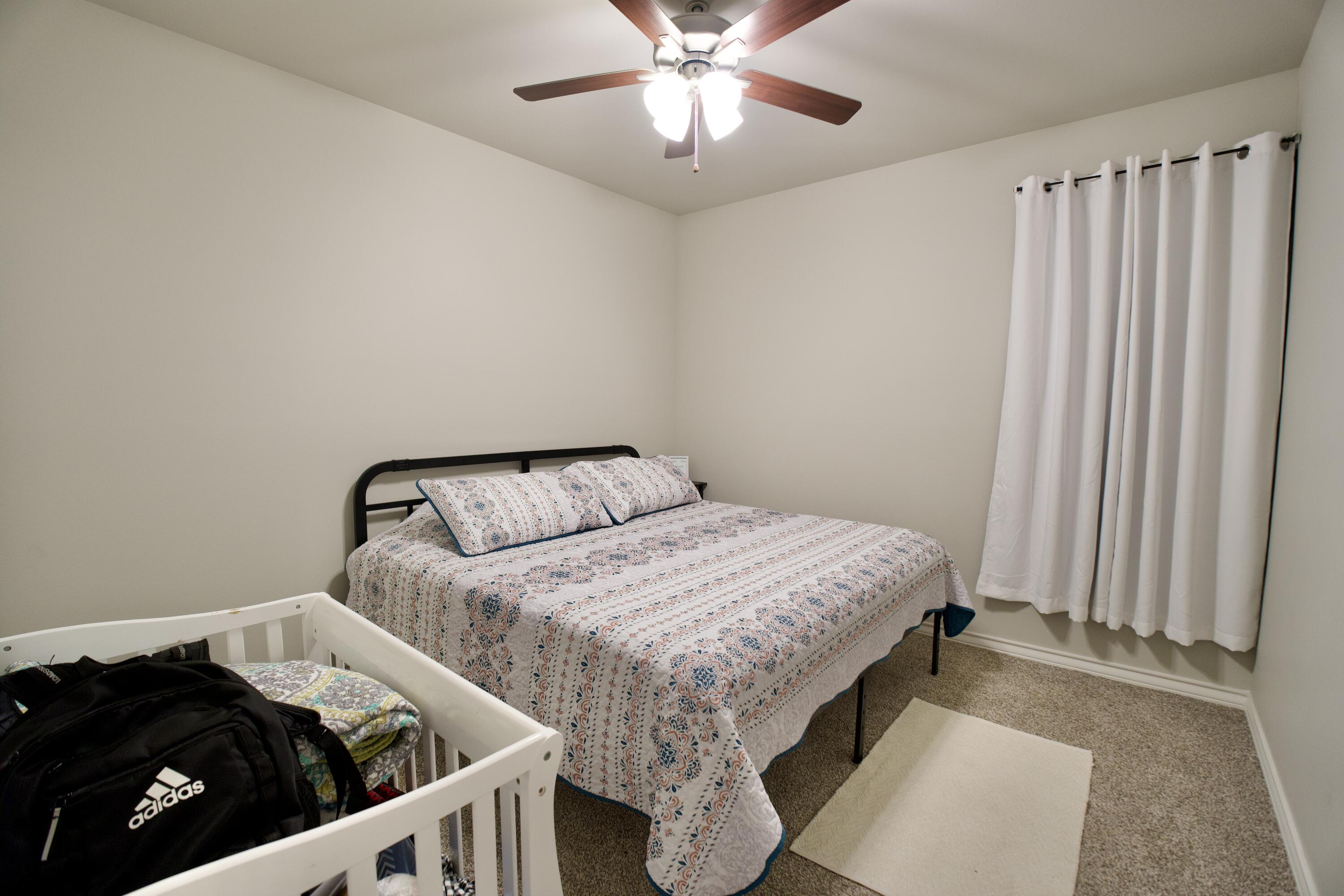 5801 Winfield Avenue Lubbock, TX 79407 - Photo 12 of 20 a bedroom with a bed and a chandelier