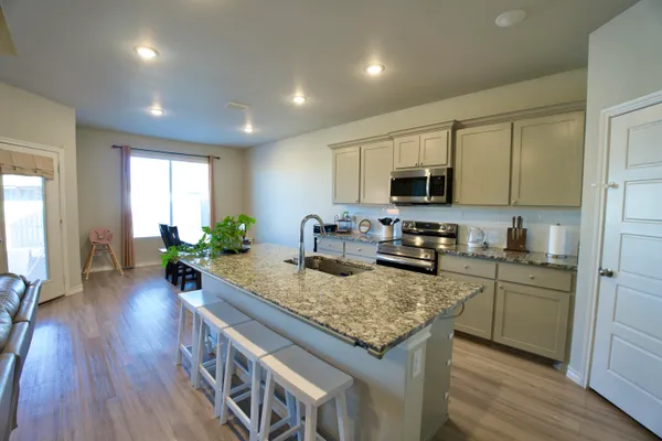 a kitchen with a center island wooden floor and stainless steel appliances