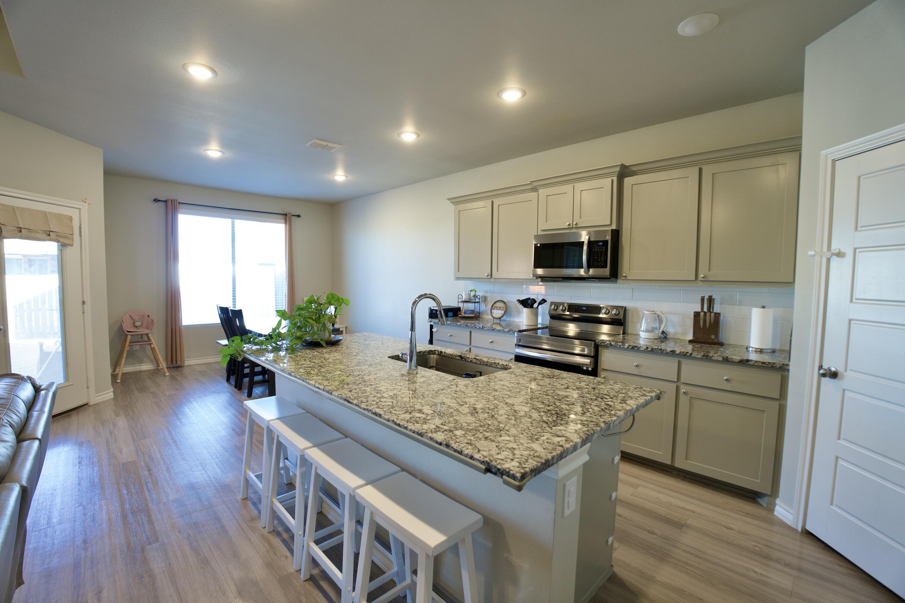5801 Winfield Avenue Lubbock, TX 79407 - Photo 4 of 20 a kitchen with a center island wooden floor and stainless steel appliances