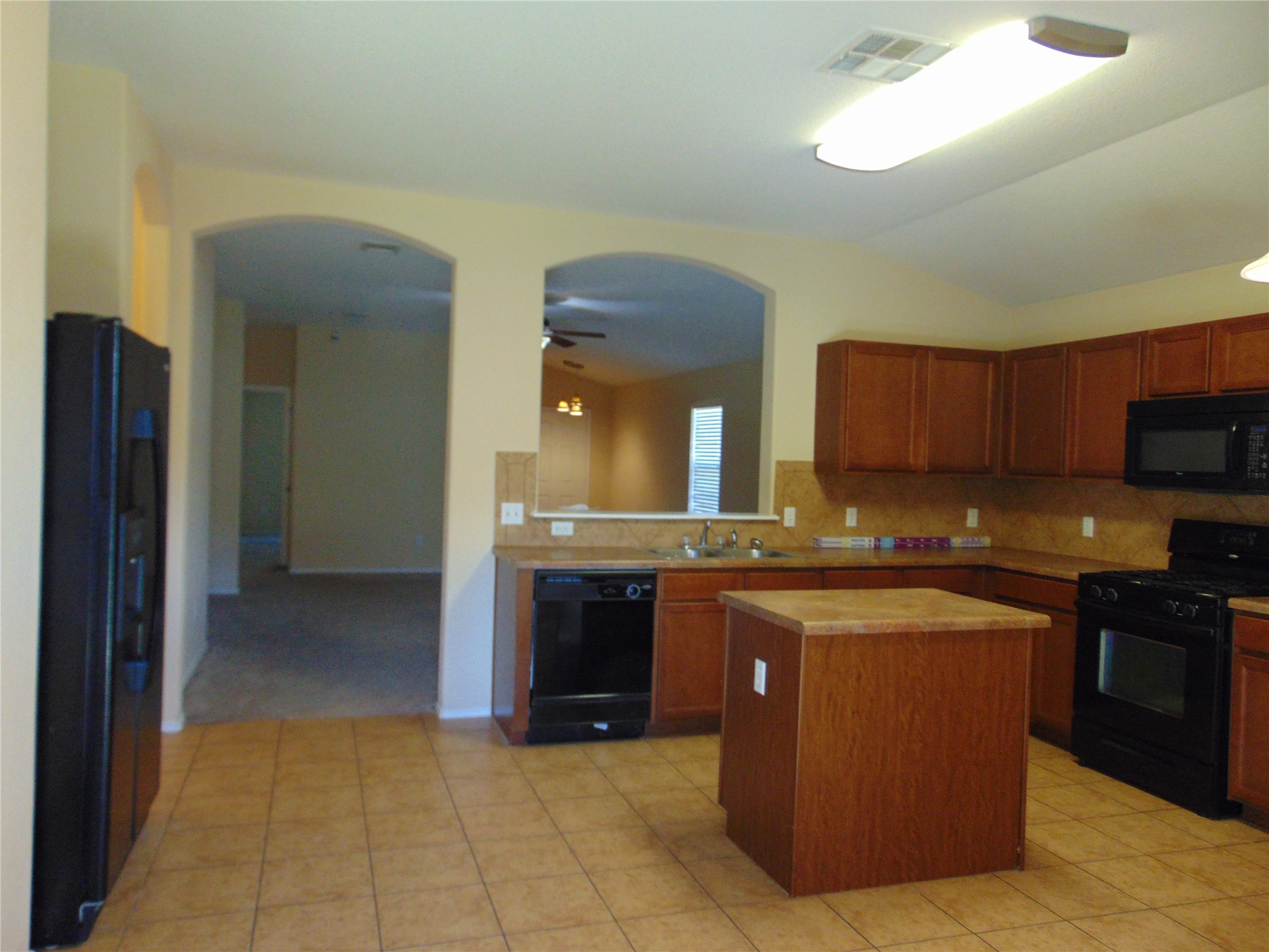 251 Wolfberry Path Buda, TX 78610 - Photo 5 of 17 a large kitchen with stainless steel appliances granite countertop a stove a sink and a refrigerator