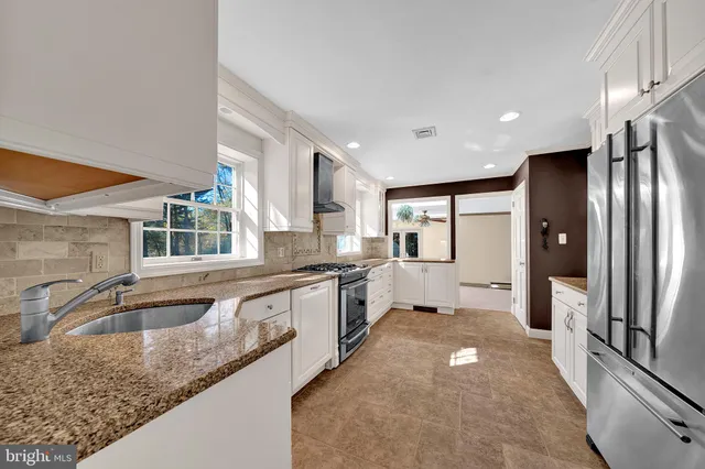 a large kitchen with stainless steel appliances granite countertop a sink and cabinets