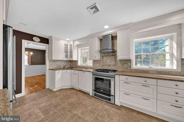 a kitchen with granite countertop a stove a sink and a refrigerator
