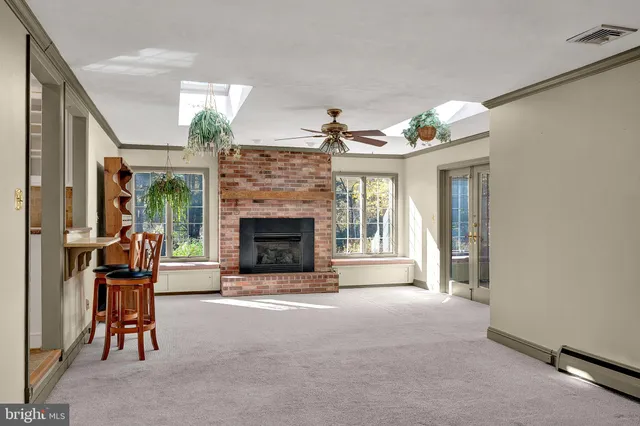 a living room with furniture a fireplace and a floor to ceiling window