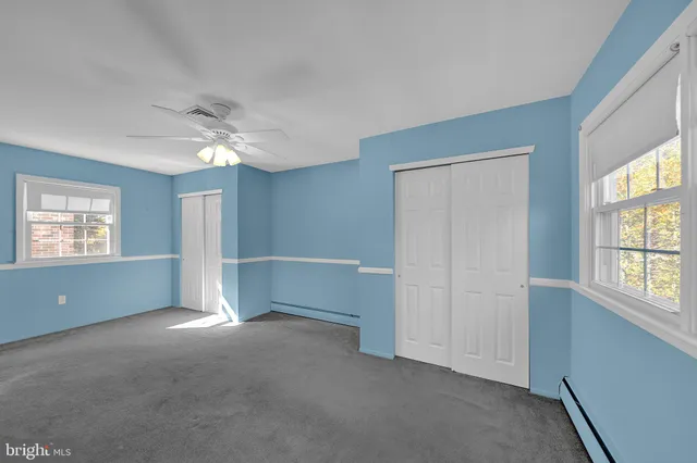 an empty room with windows and closet