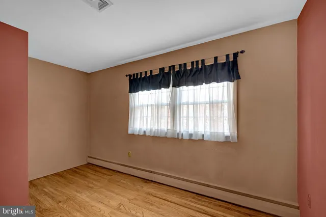 a view of a room with a window and a bed