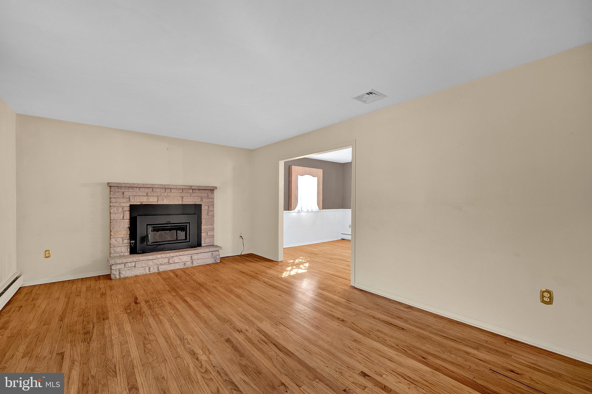 4 Old Forge Lane Ewing, NJ 08618 - Photo 7 of 35 a view of an empty room with wooden floor fireplace and a window