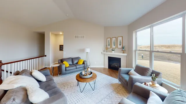 a living room with furniture fireplace and a large window