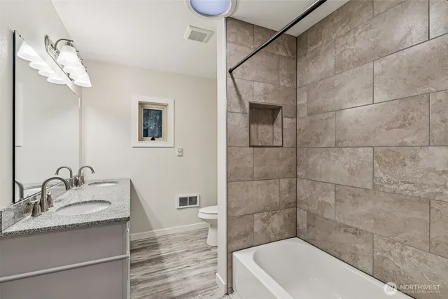a bathroom with a tub a sink and mirror