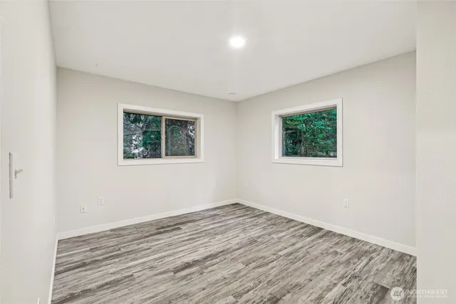 a view of empty room with wooden floor