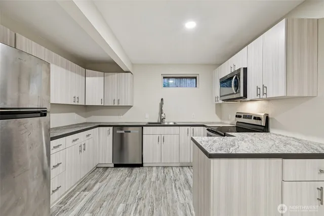 a kitchen with granite countertop a sink stove and cabinets