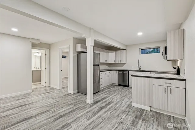a large kitchen with a wooden floor and stainless steel appliances