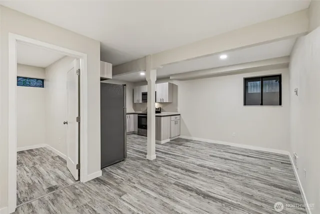 a view of a kitchen with wooden floor and a refrigerator