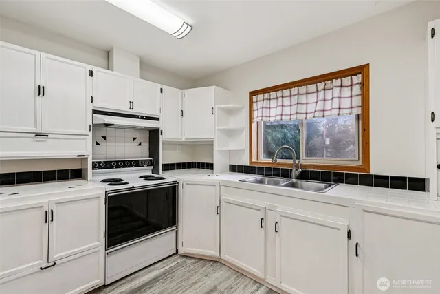 a kitchen with white cabinets and white stainless steel appliances