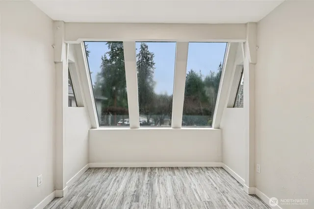 an empty room with wooden floor and a window
