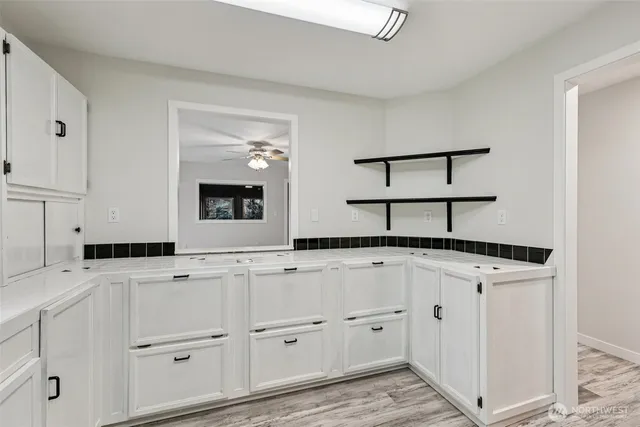 a kitchen with granite countertop white cabinets and white appliances