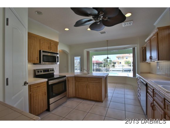 117 Inlet Harbor Road Ponce Inlet, FL 32127 - Photo 3 of 24 a kitchen with stainless steel appliances granite countertop a sink and a stove