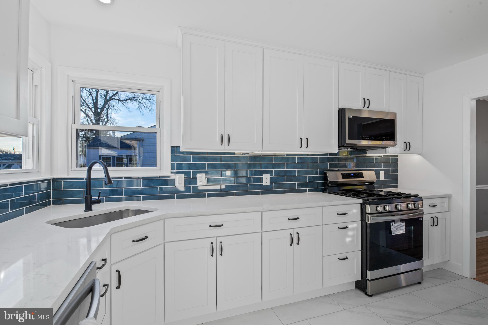 504 River Drive Riverside, NJ 08075 - Photo 10 of 45 a kitchen with white cabinets and stainless steel appliances