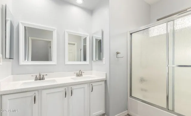 a bathroom with a double vanity sink mirror and