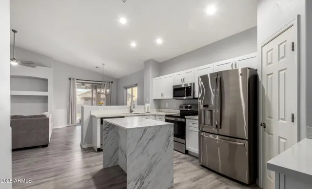 a kitchen with stainless steel appliances a refrigerator a stove a sink and a refrigerator